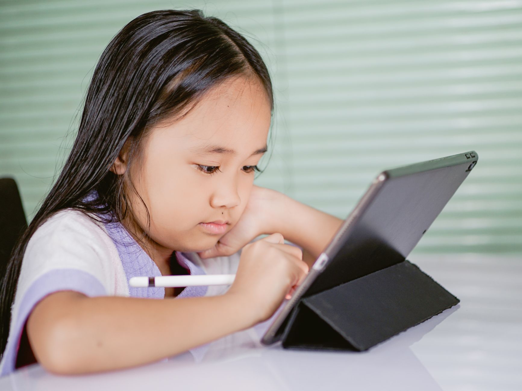Child learning money skills on a tablet with a parent nearby