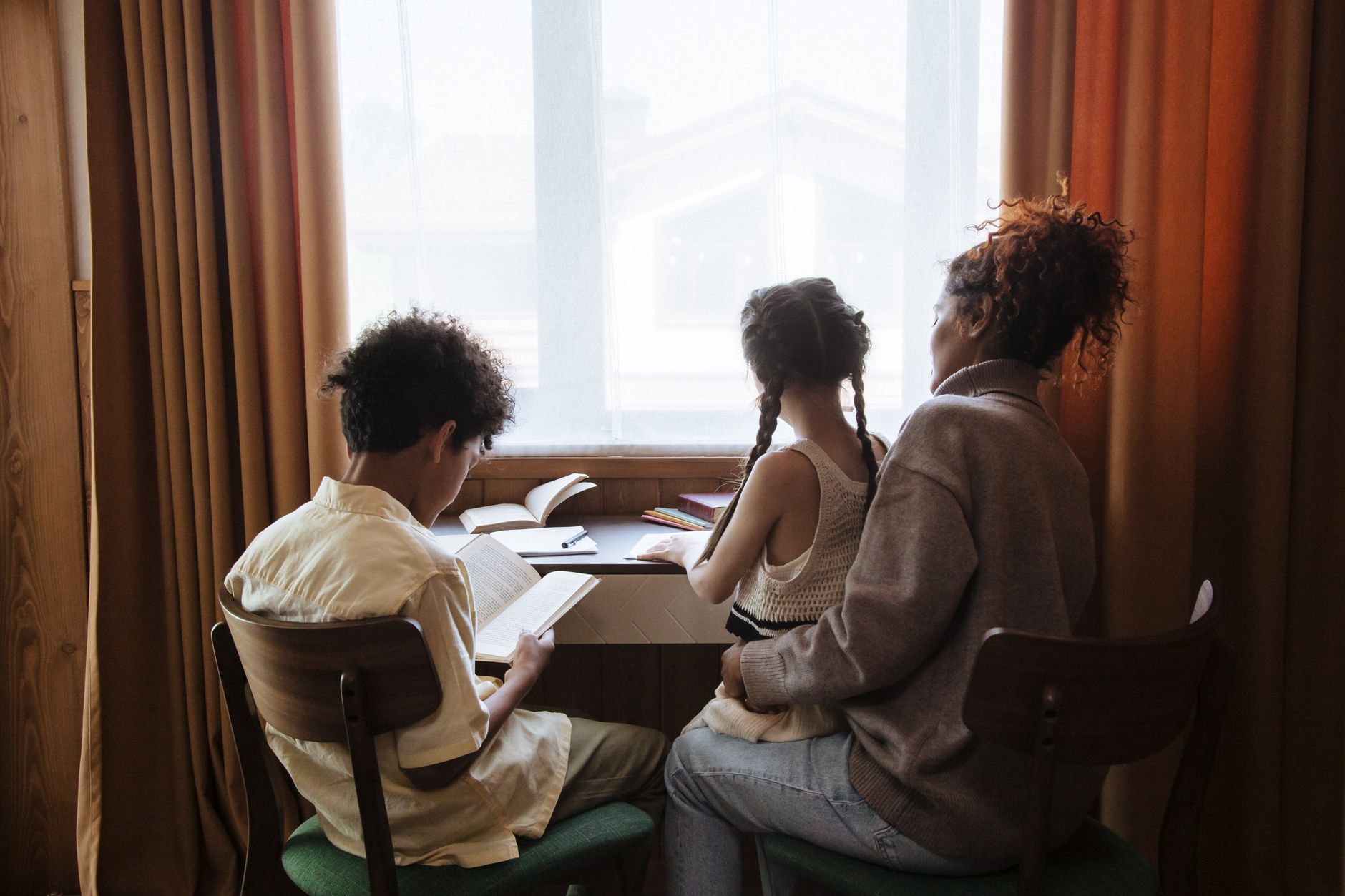 Parent and child working on homeschool financial literacy curriculum together with workbook and calculator