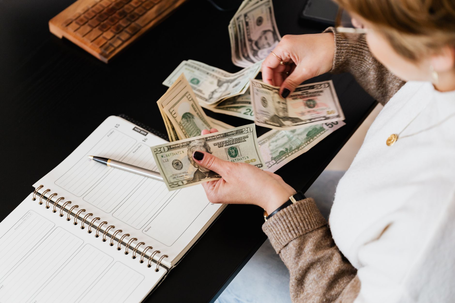 A teenager organizing money and budgeting with a calculator and notebook