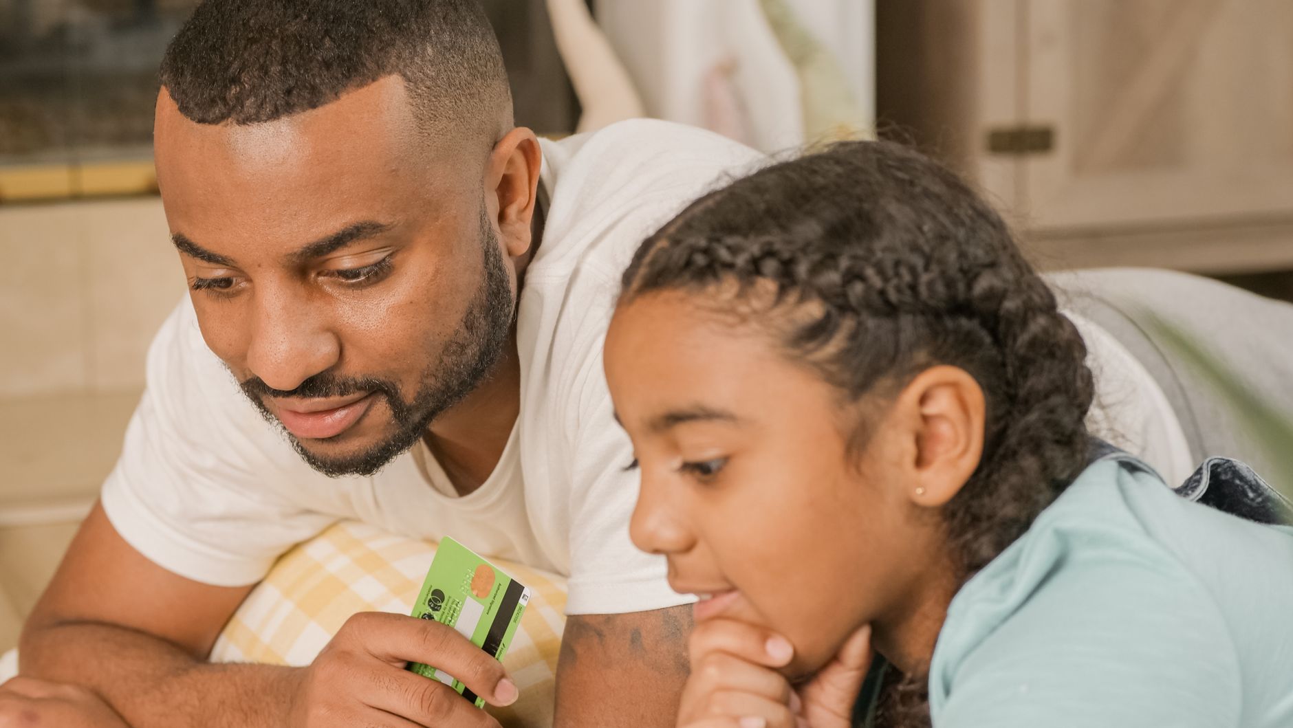 Parent and child sitting together reviewing financial concepts at a table
