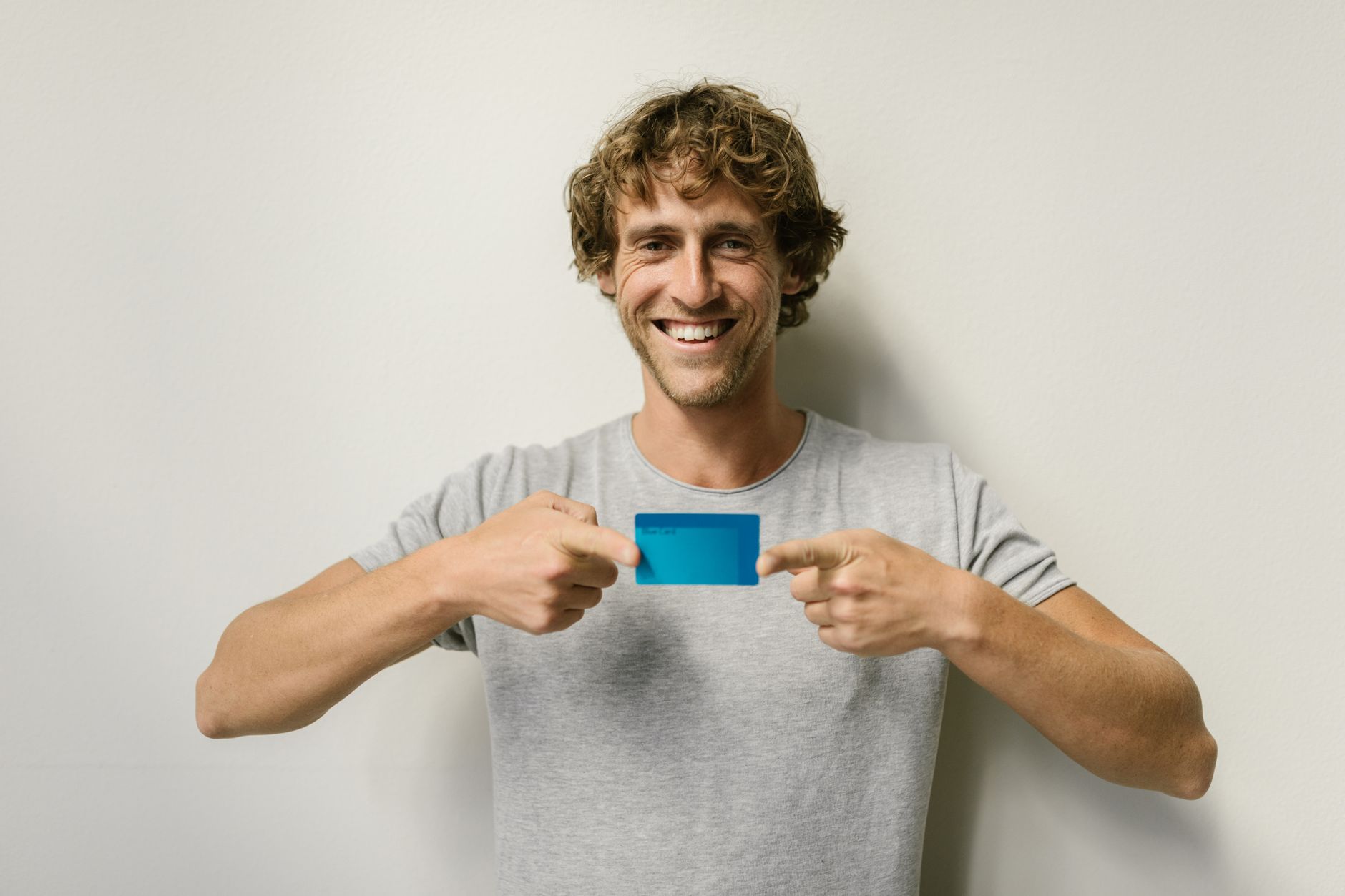 Young adult holding a credit card, learning how to build credit at 17