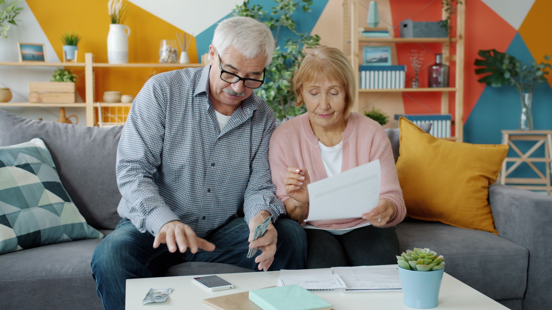 Parent and child sitting at kitchen table looking at a budget together