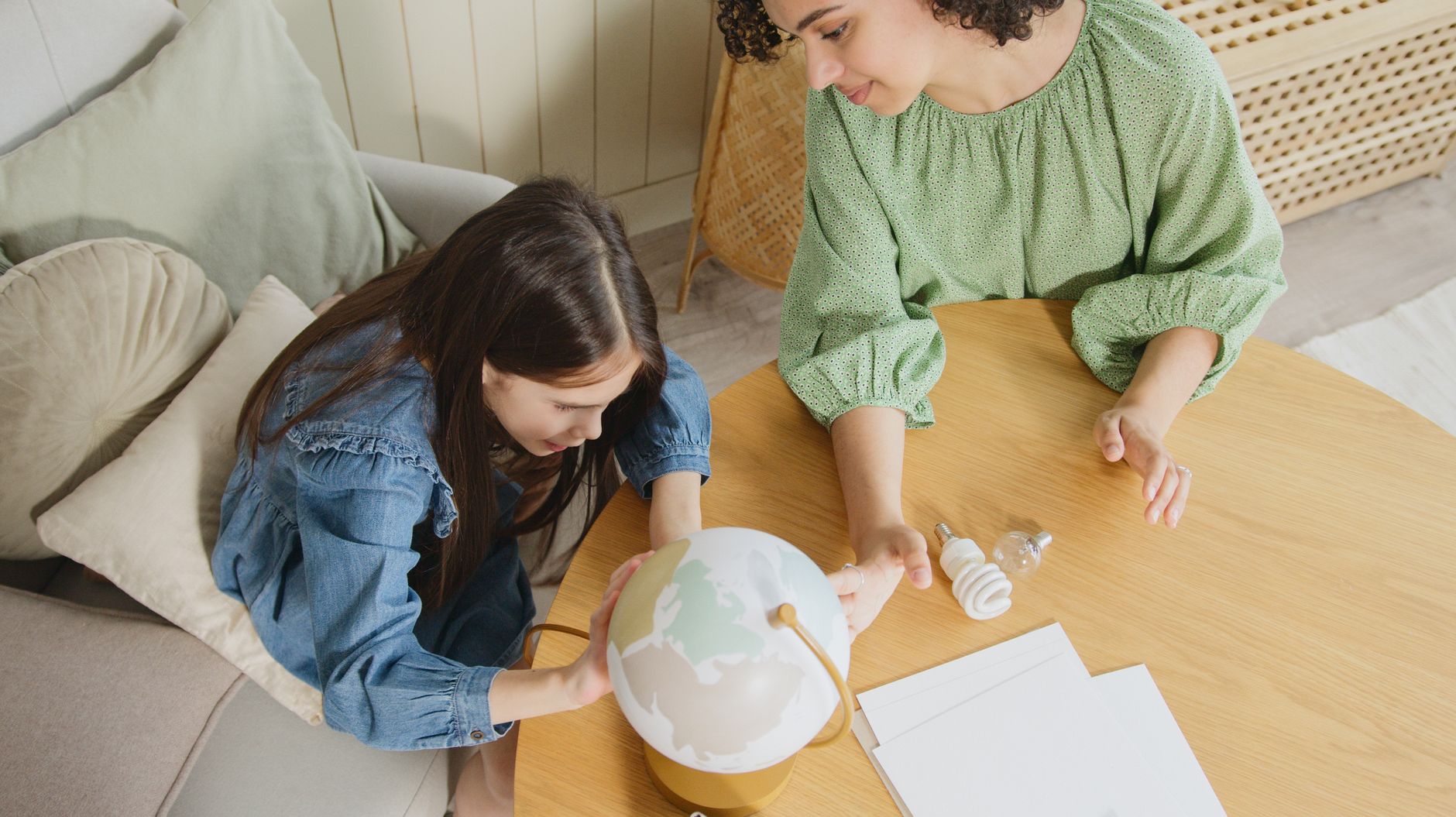 Parent teaching child about compound interest with savings jars and calculator
