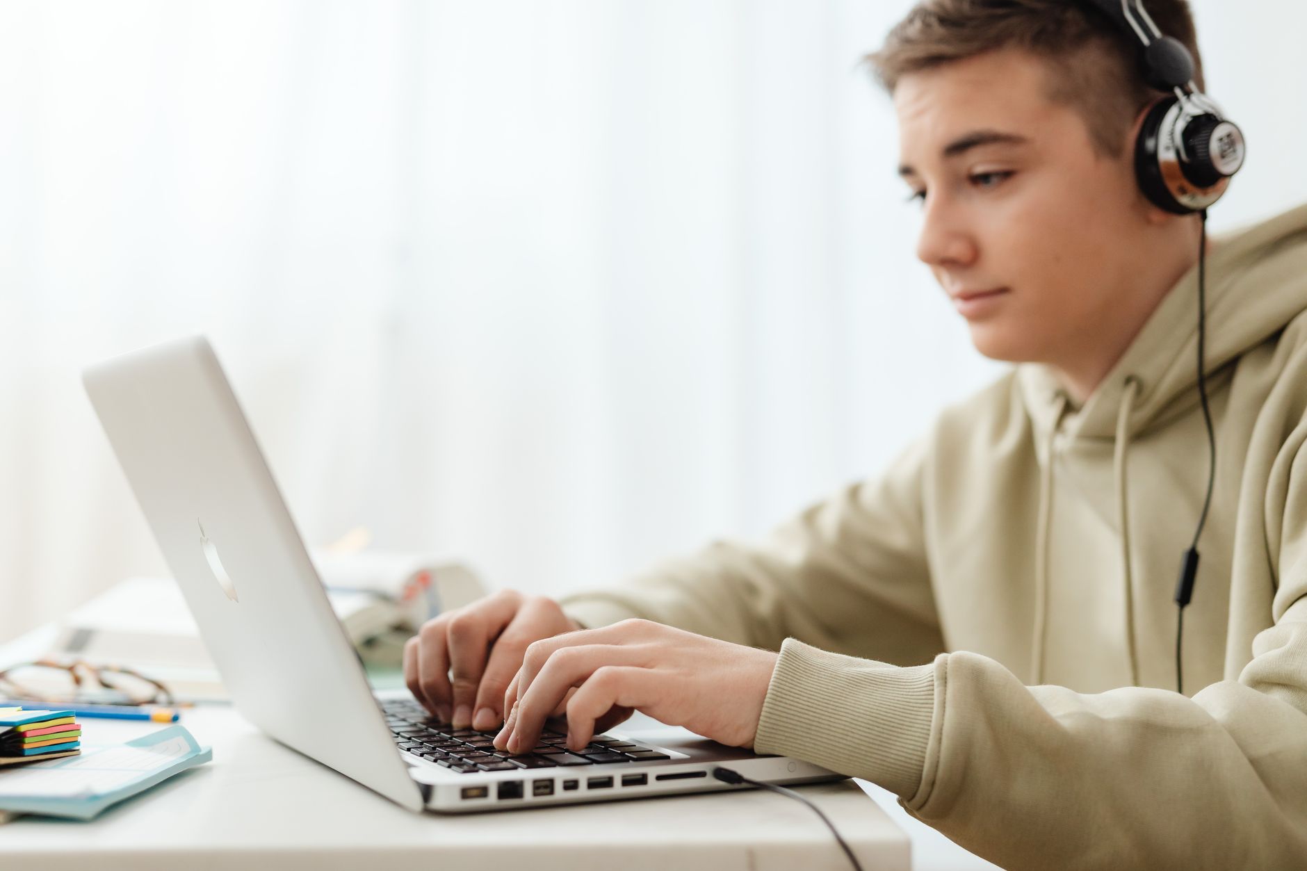 Teenager learning about stock market investing on a laptop at home