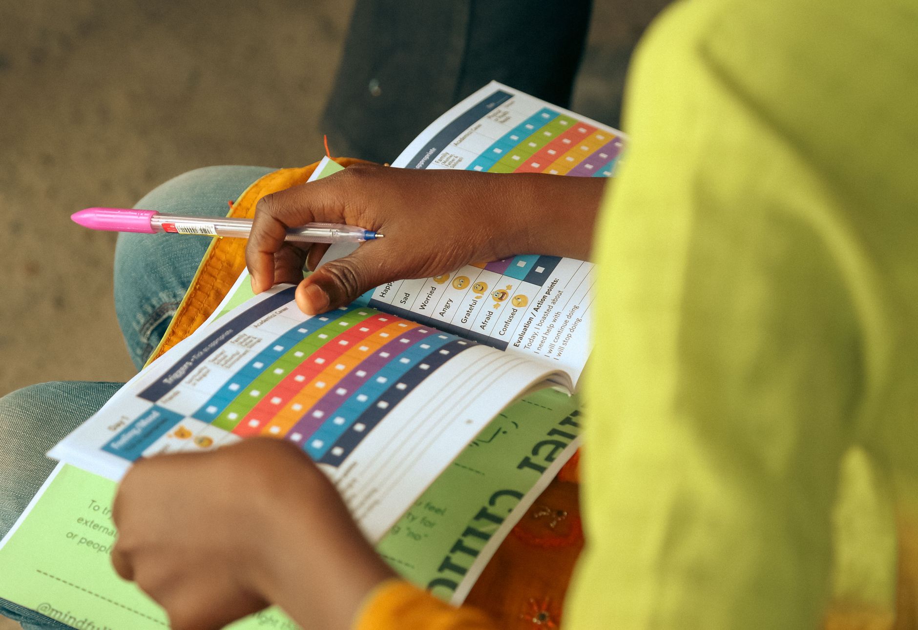 Child engaging with a colorful educational workbook, learning money skills