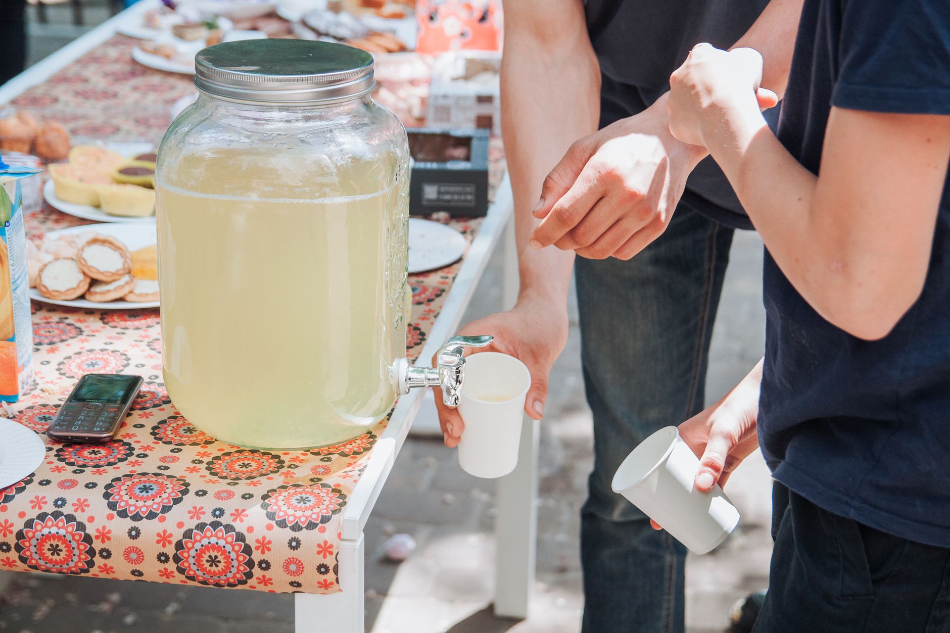 Kids learning entrepreneurship with a lemonade stand on a sunny day