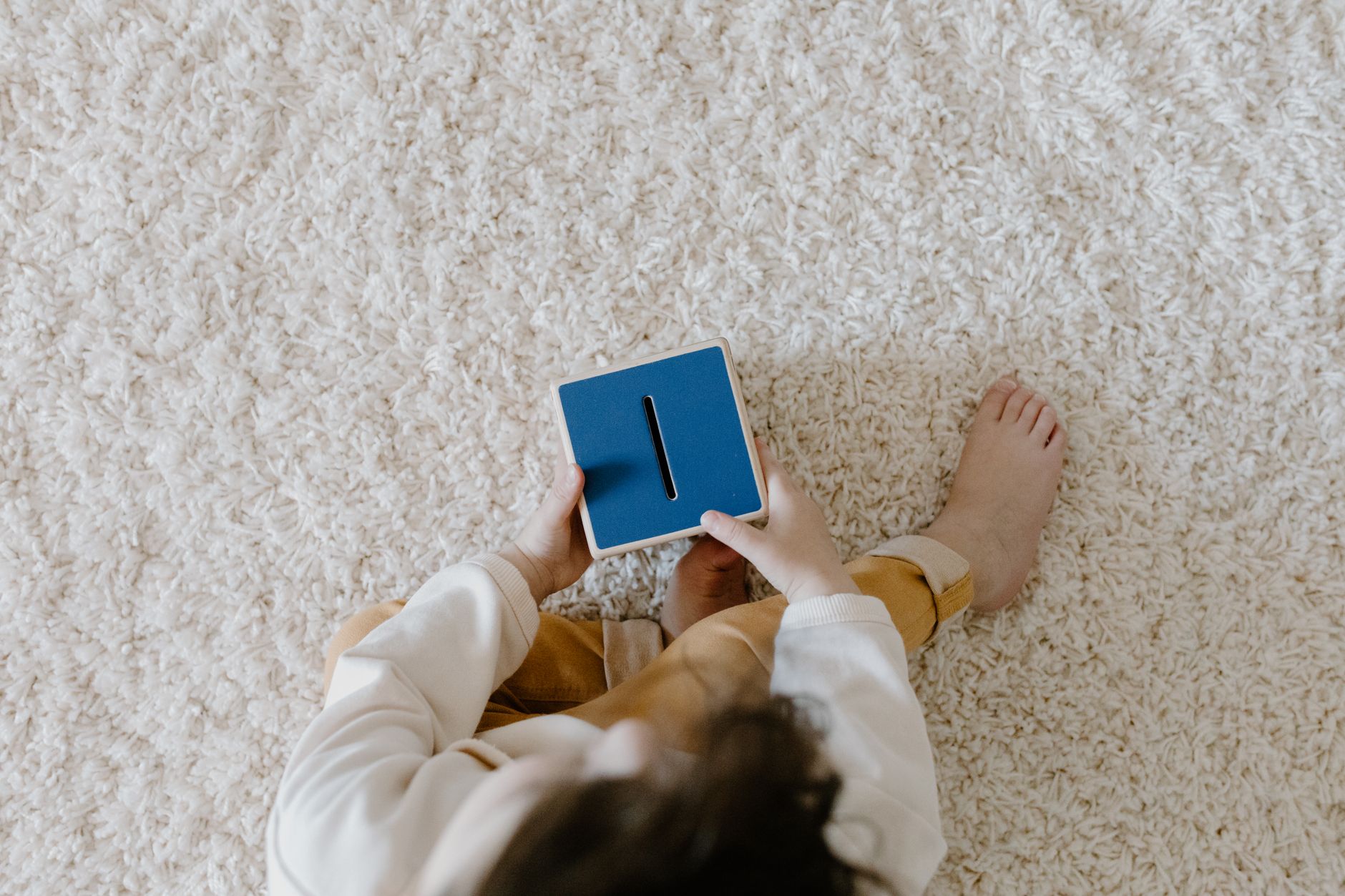 Child holding a blue piggy bank, learning about money management