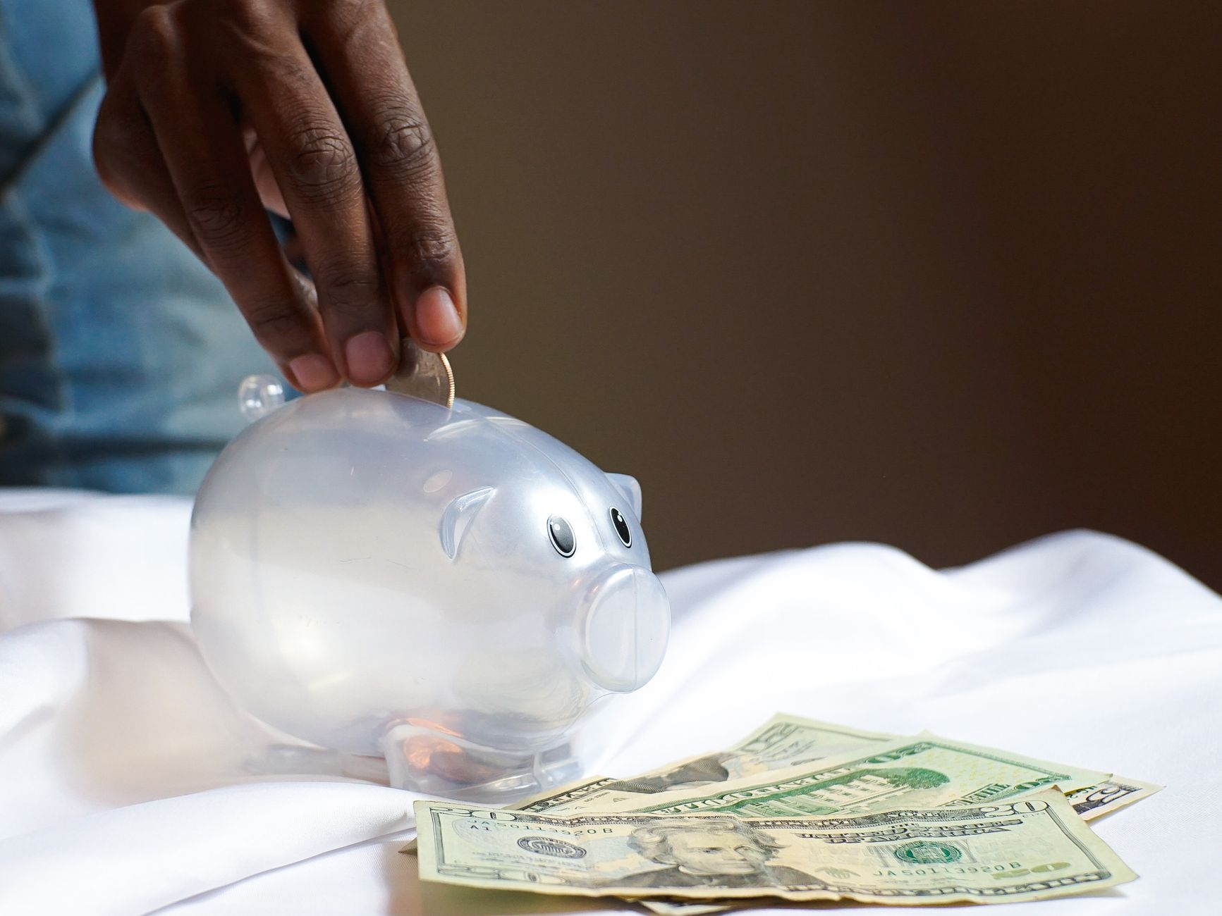 Child counting coins at a table with a parent, working toward a savings goal