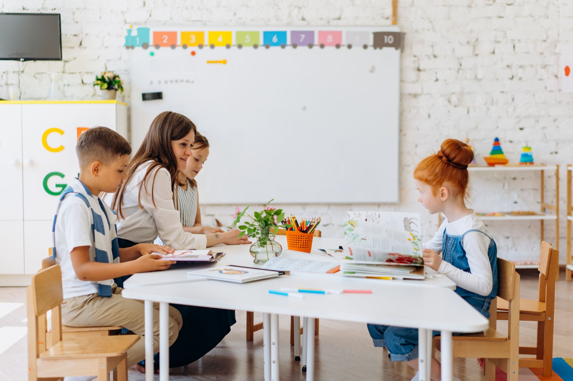 Parent and child sitting at kitchen table learning about money with coins and a piggy bank