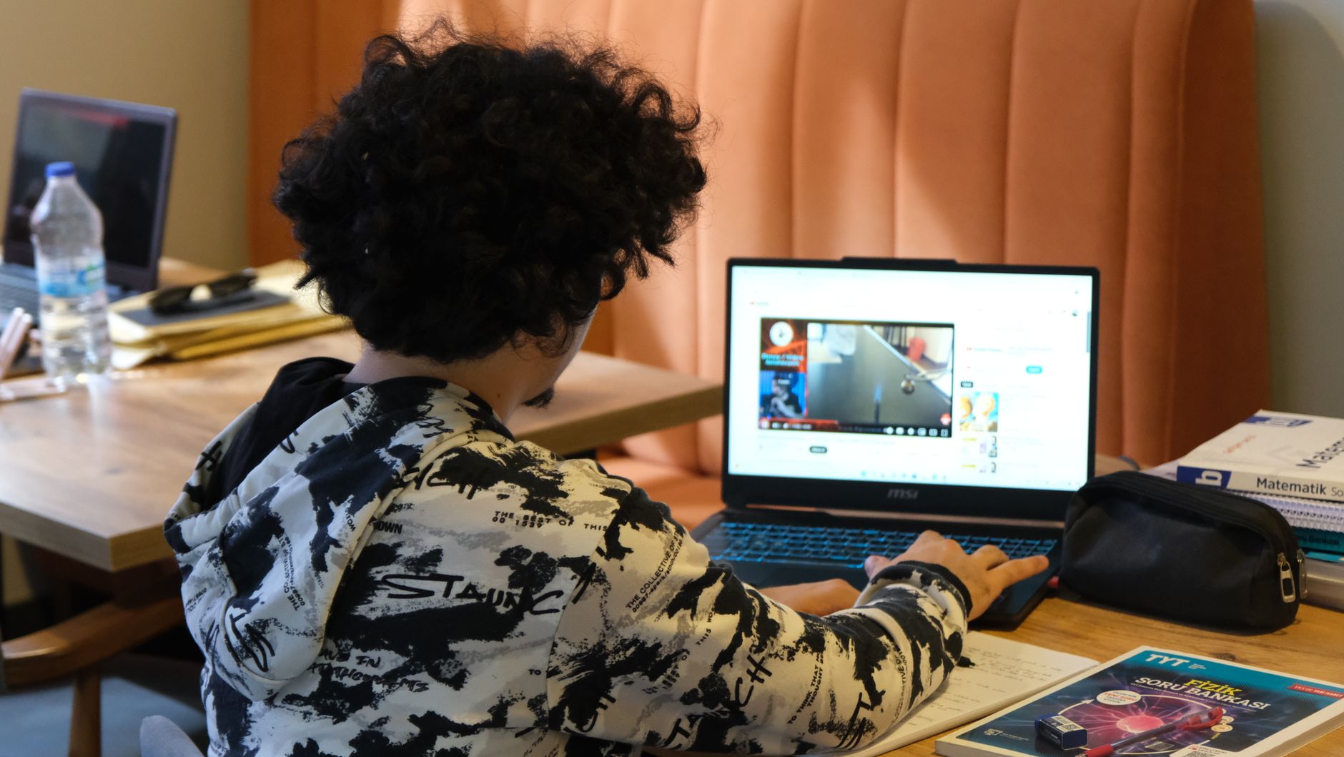 Teenager using a laptop to take an online money course at home