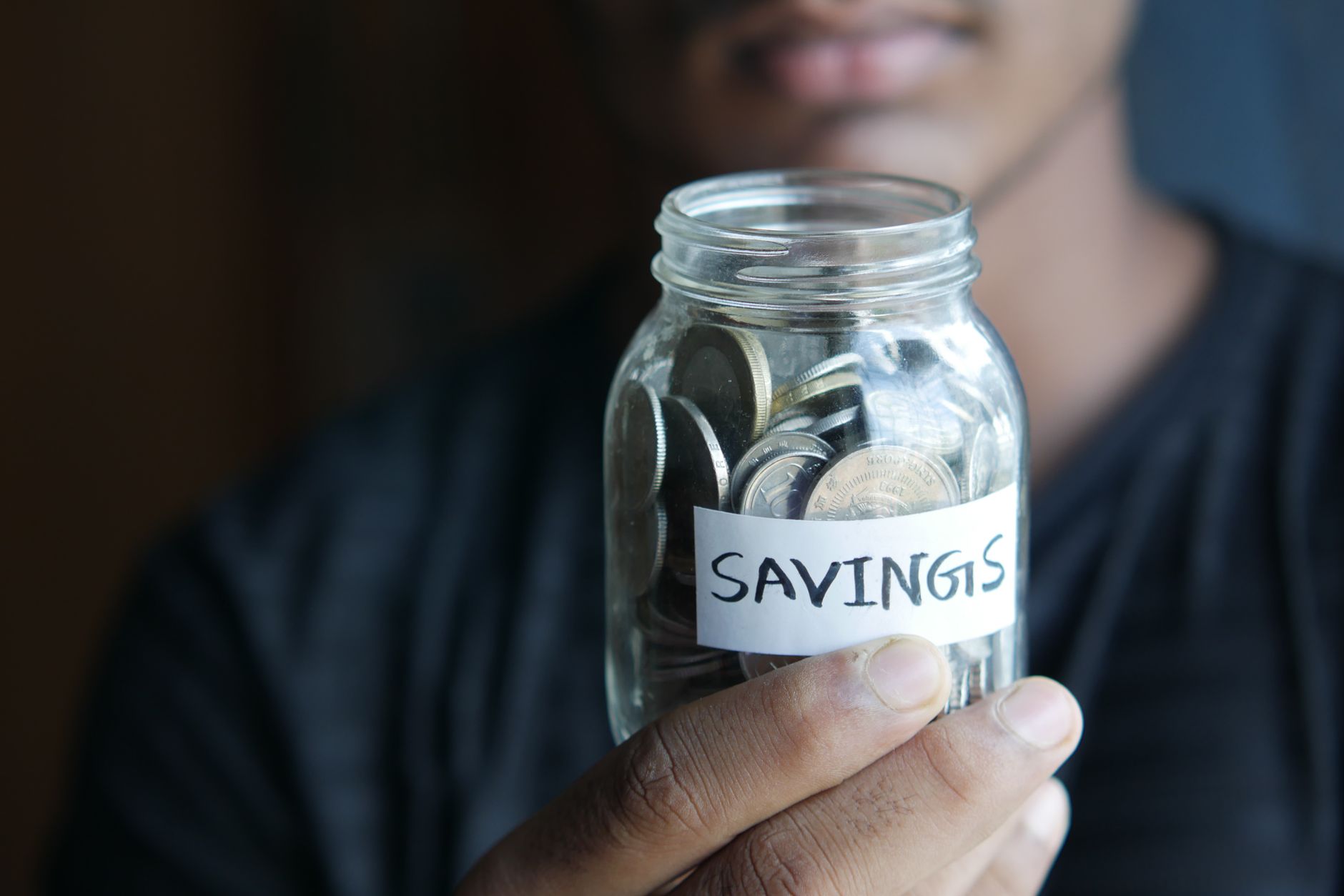 Teen holding a savings jar, representing a Roth IRA for teenagers